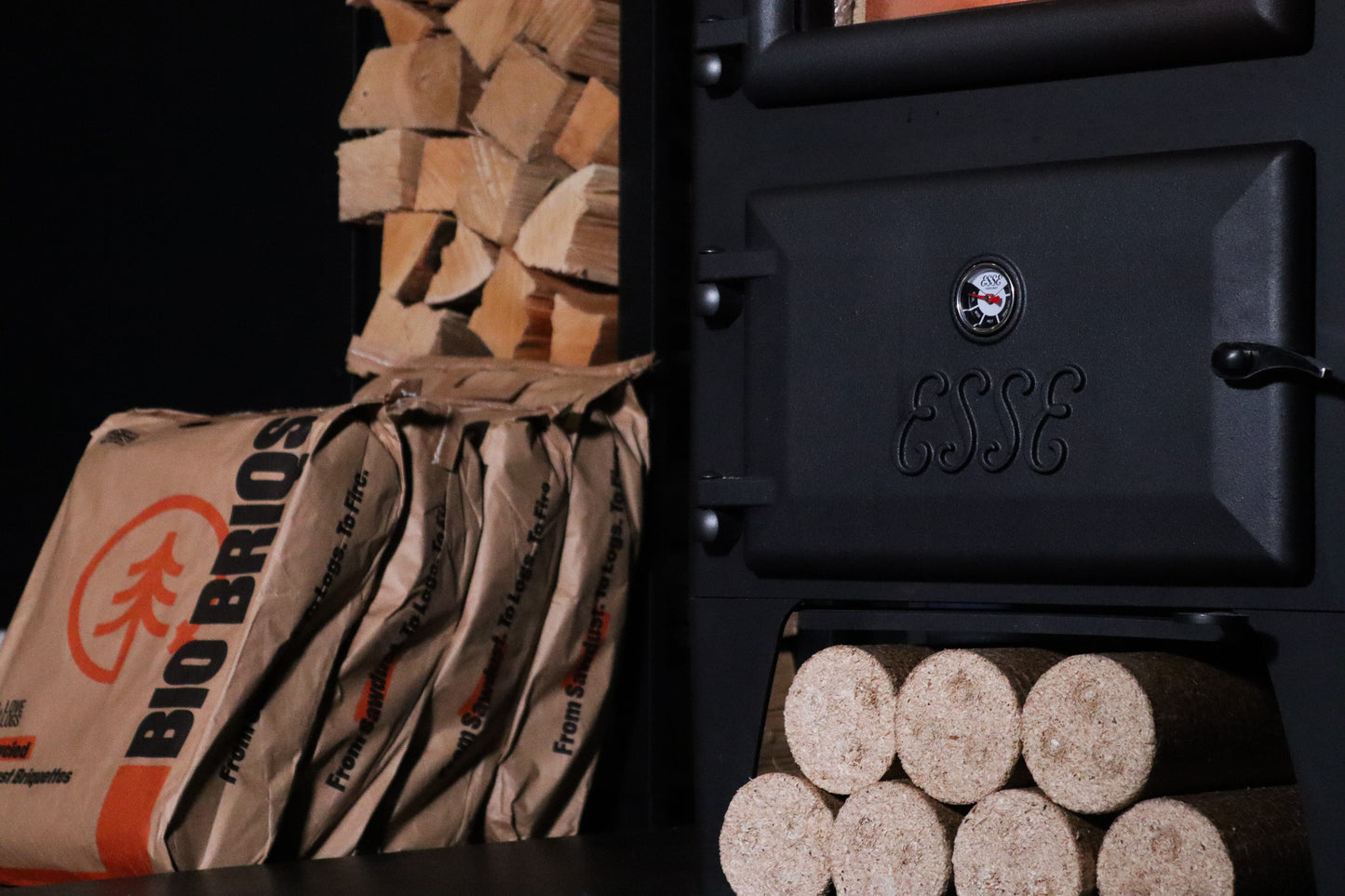 Bio Briqs firewood briquettes stackked in bags nest to log burner