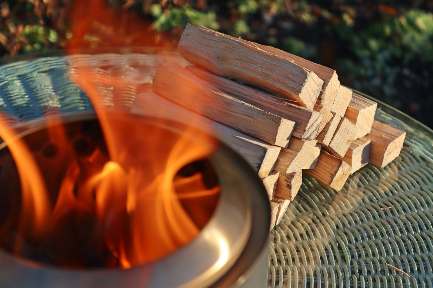 Love Logs Mini Fire Pit Wood burning cleanly in Mesa XL with wood stacked in the background