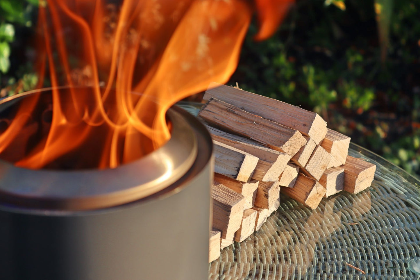 Love Logs Mini Fire Pit Wood burning cleanly in Mesa XL with wood stacked in the background