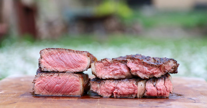 Two steaks cut through the middle to show they are cooked rare