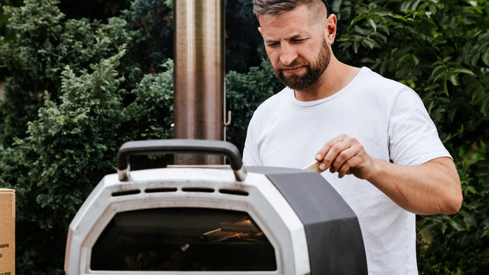 Paul putting wood into he back of the Ooni Karu 16