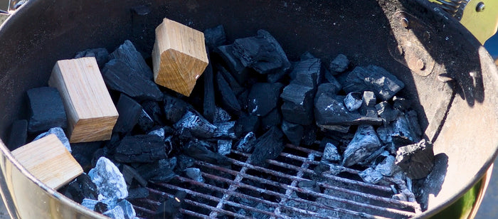 BBQ filled with charcoal and smoking wood chunks