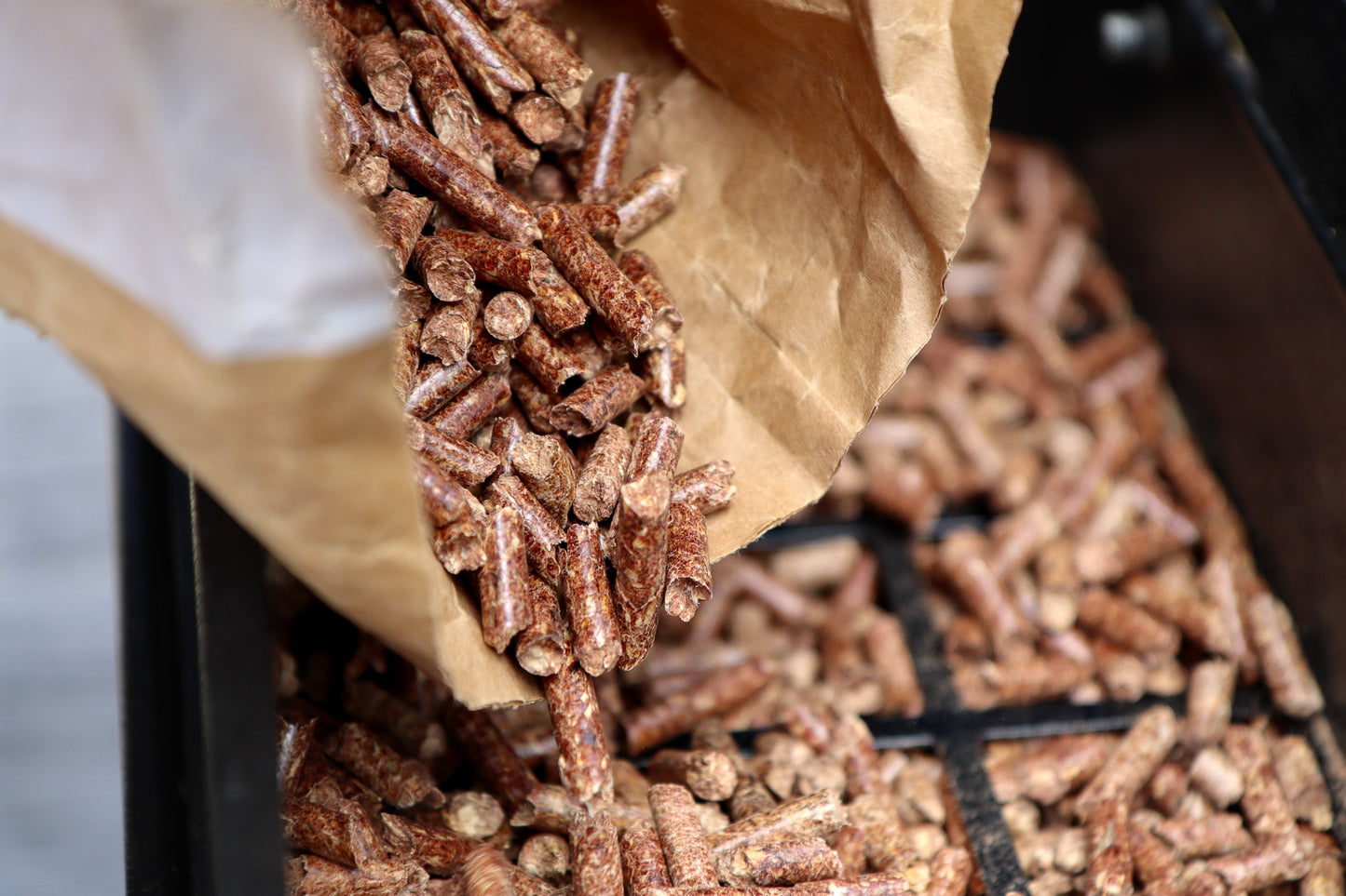 Close up of Love Logs British BBQ & Smoker Pellets being poured into smoker