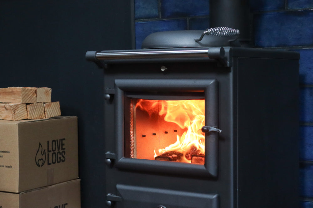 Roaring fire inside a log burner with Love Logs kiln-dried firewood in background
