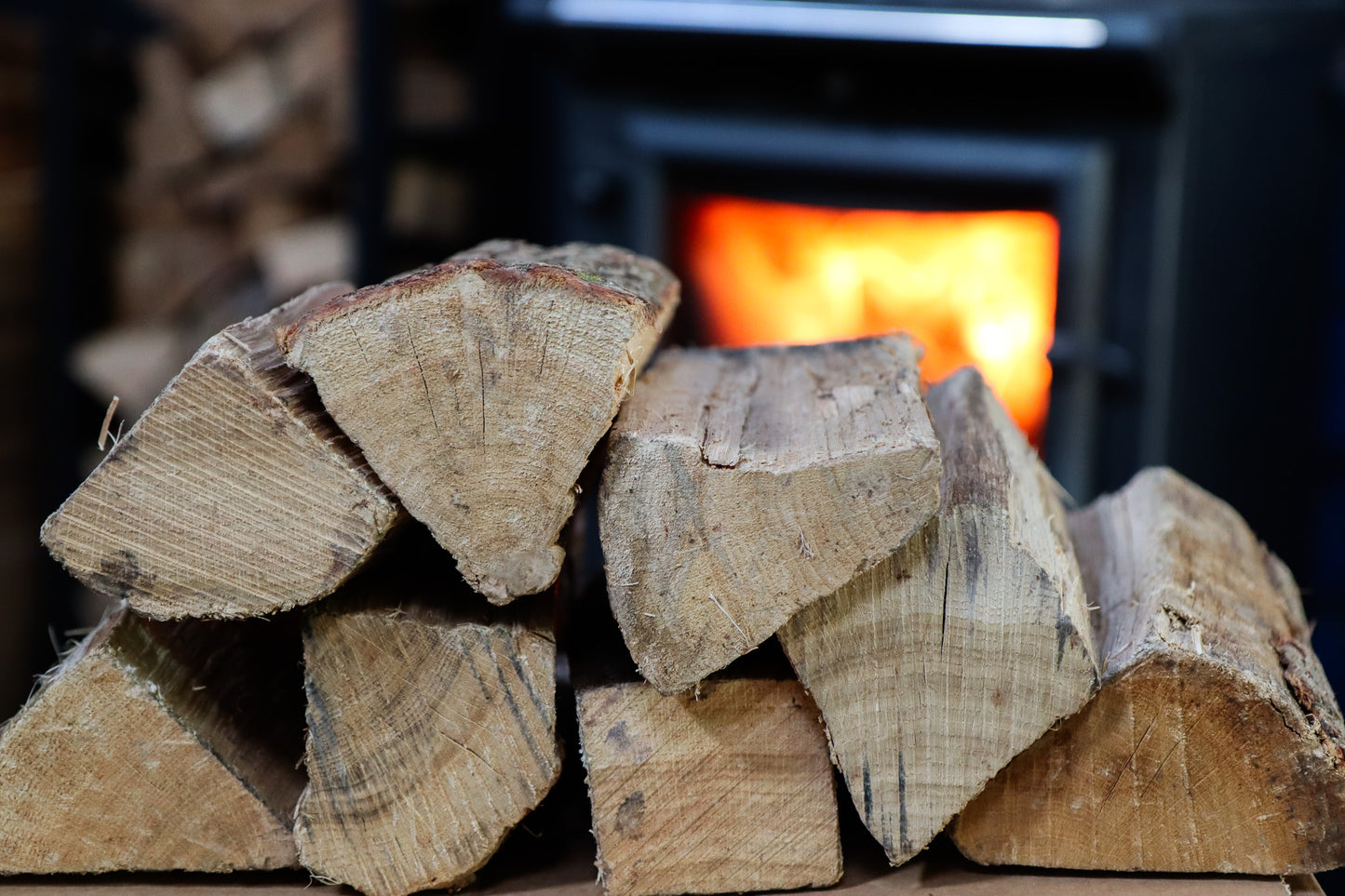 Oak logs in front of lit log burner