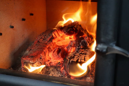 Love Logs kiln-dried firewood burning down to embers in log burner
