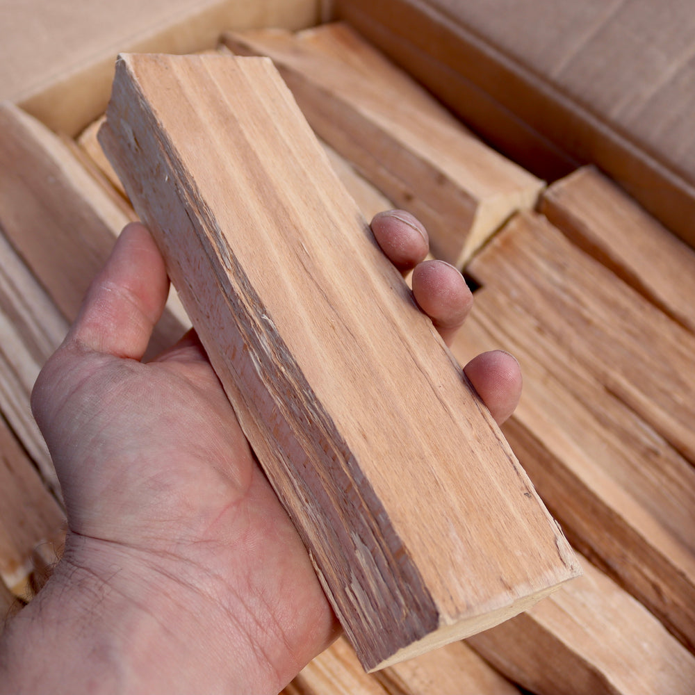 20cm kiln dried beech log for Ooni pizza ovens held in a hand